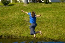 boy jumps across a ditch