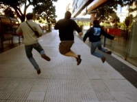 three friends jumping on the street